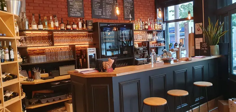 Comptoir de bar terminé avec étagères à bouteilles et mur de brique