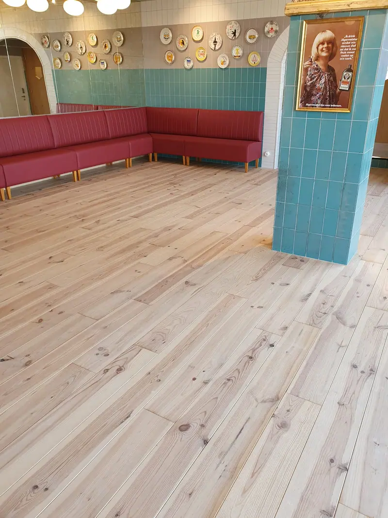 Banquette d’angle devant un mur de faïence turquoise conservé