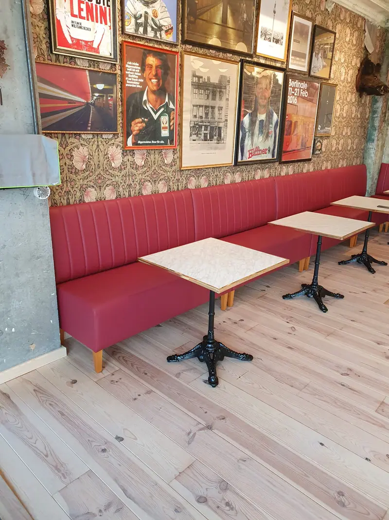 Alignement de banquettes et de tables dans la salle du bar