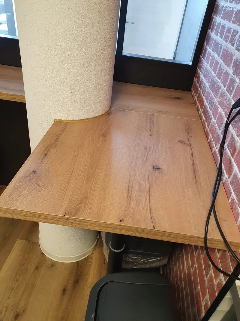 Tablette haute en bois fixée devant un mur de brique
