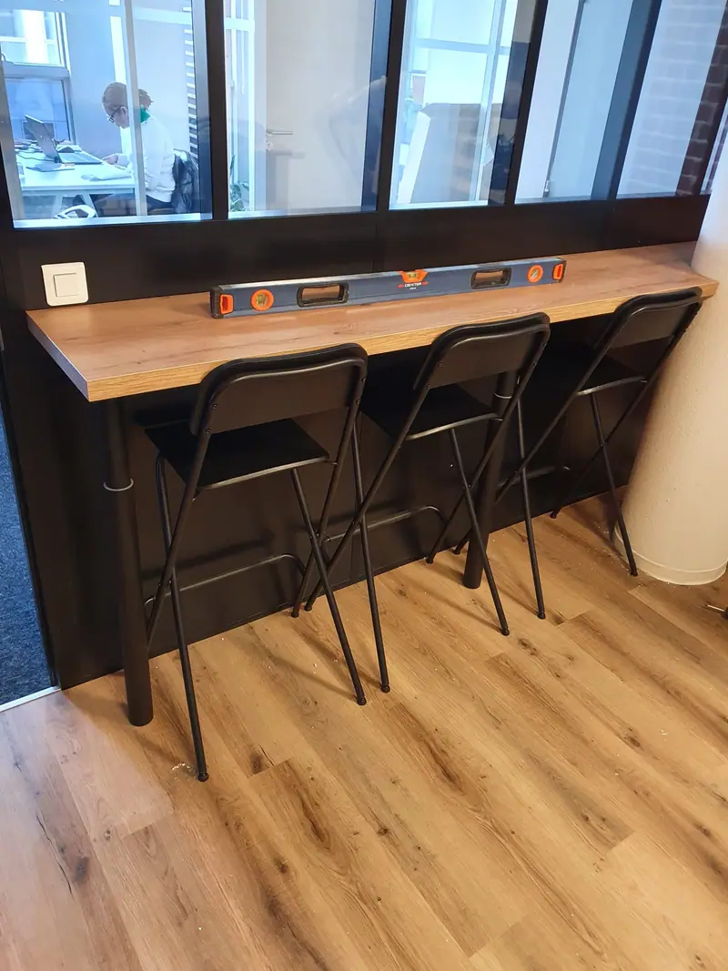 Tablette haute et tabourets installés le long d’une verrière