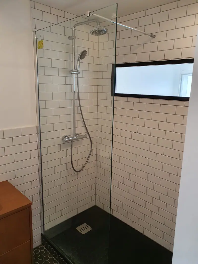 Douche à l'italienne avec paroi vitrée, faïence métro et receveur noir