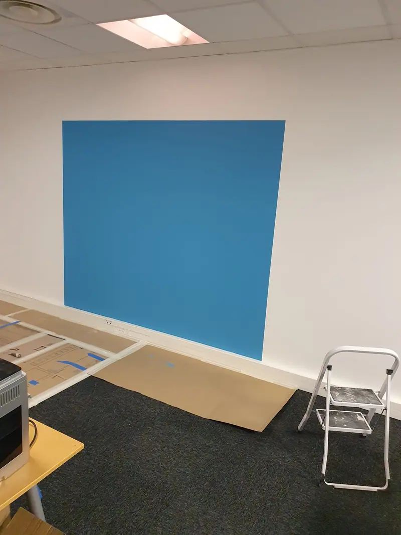 Aplat de peinture bleu sur un mur blanc fraîchement repeint