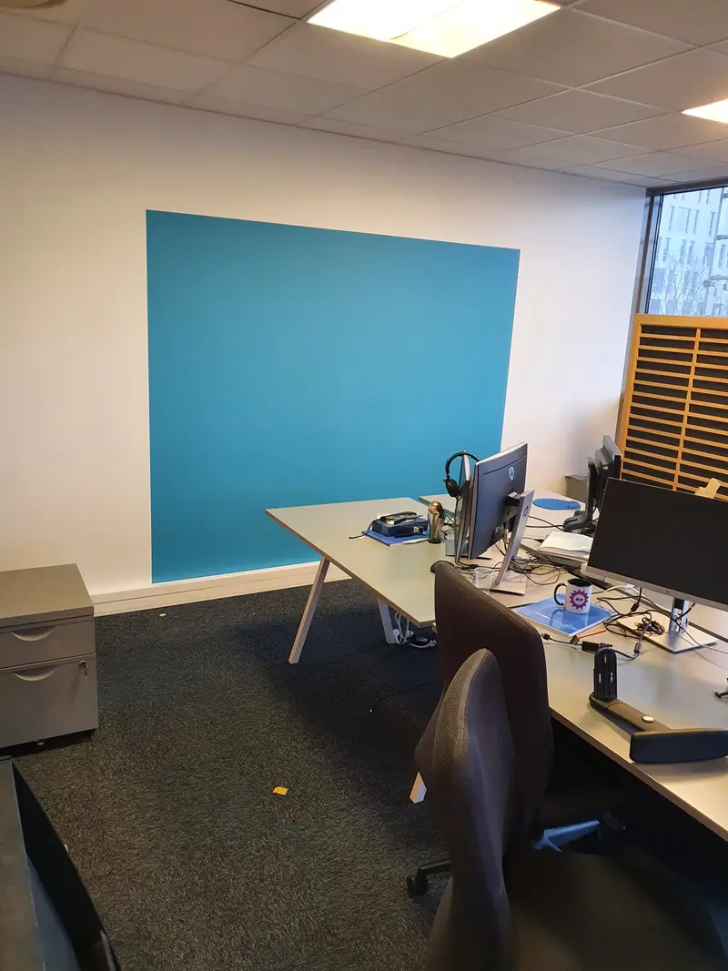 Aplat de peinture bleu dans un open space aménagé