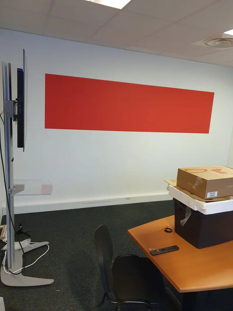 Aplat de peinture rouge sur un mur de bureau