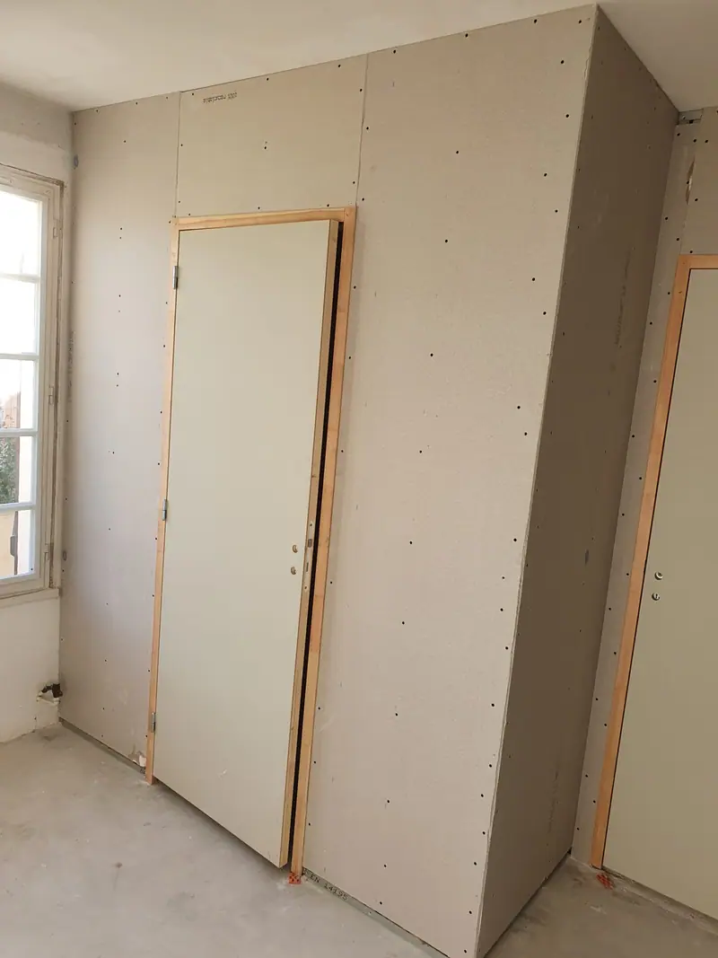 Doublage périphérique en plaques de plâtre dans une pièce en rénovation