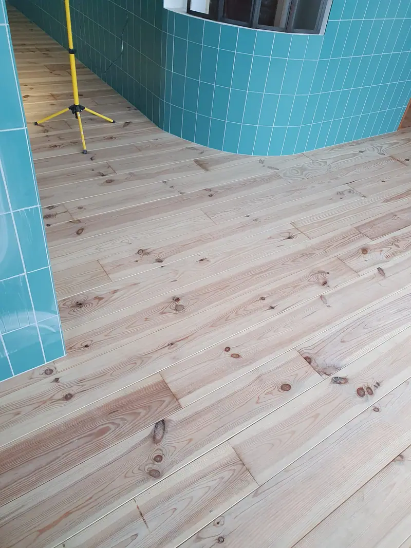 Ajustage des lames de plancher autour d’un poteau carrelé