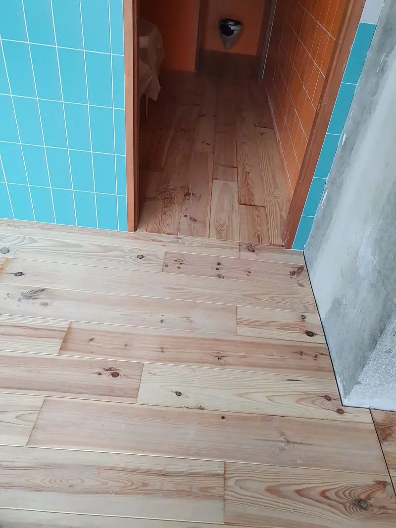 Plancher en pin massif se prolongeant dans un couloir
