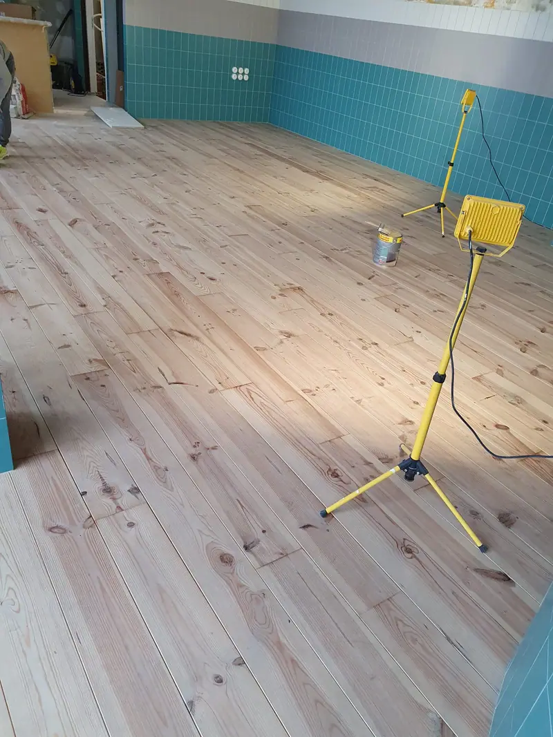 Plancher en pin massif posé dans la pièce principale du local