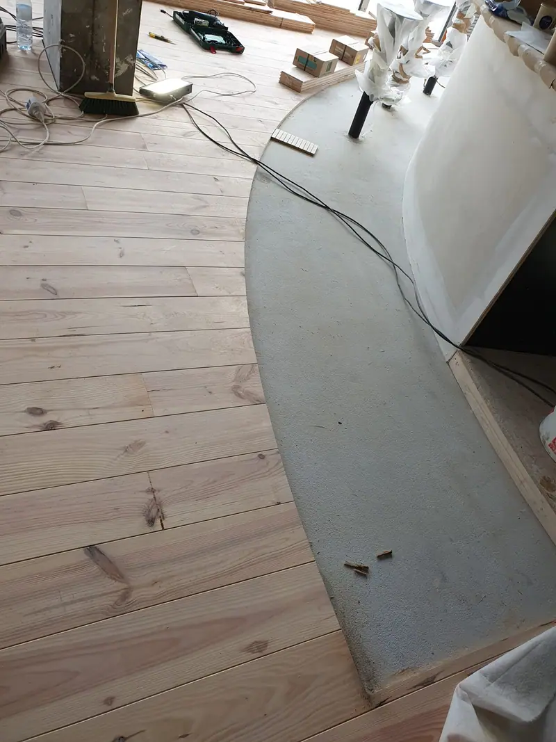 Pose du plancher en pin massif en cours de progression