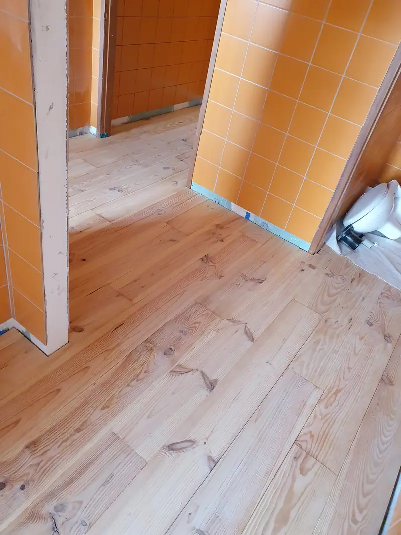 Jonction du plancher avec un mur de faïence orange conservé