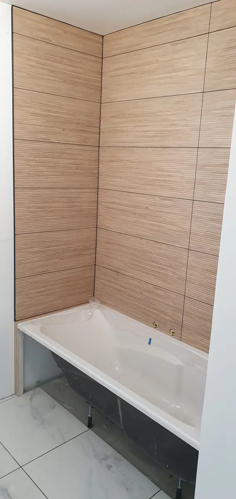 Baignoire encastrée avec tablier carrelé et faïence effet bois