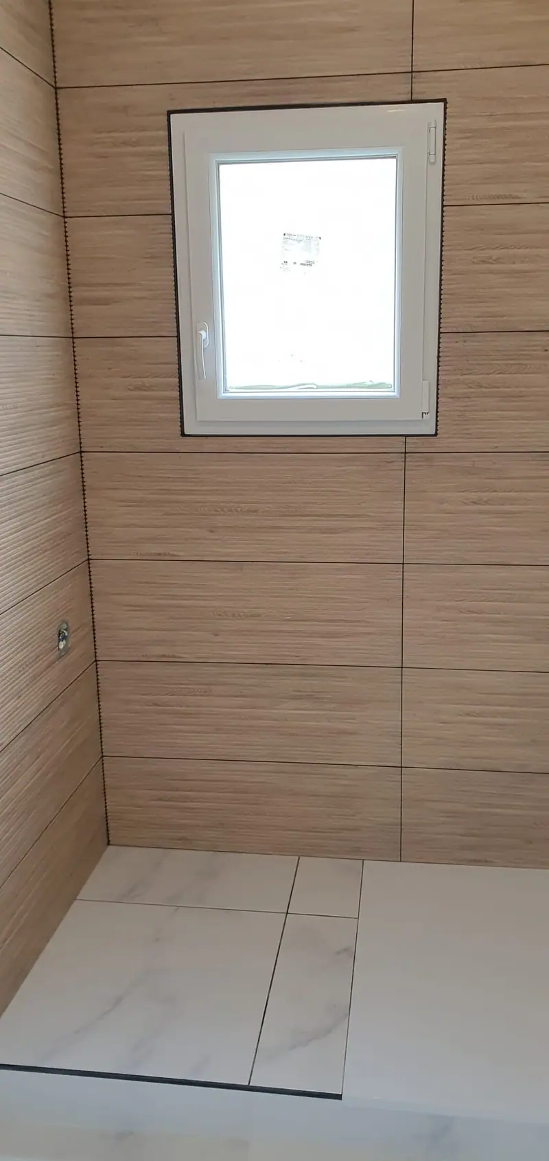 Douche à l'italienne éclairée par une fenêtre, faïence effet bois