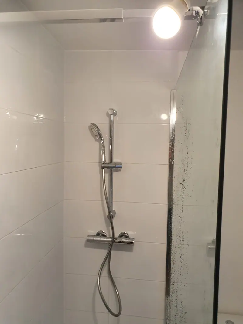 Douche en faïence blanche brillante avec colonne de douche
