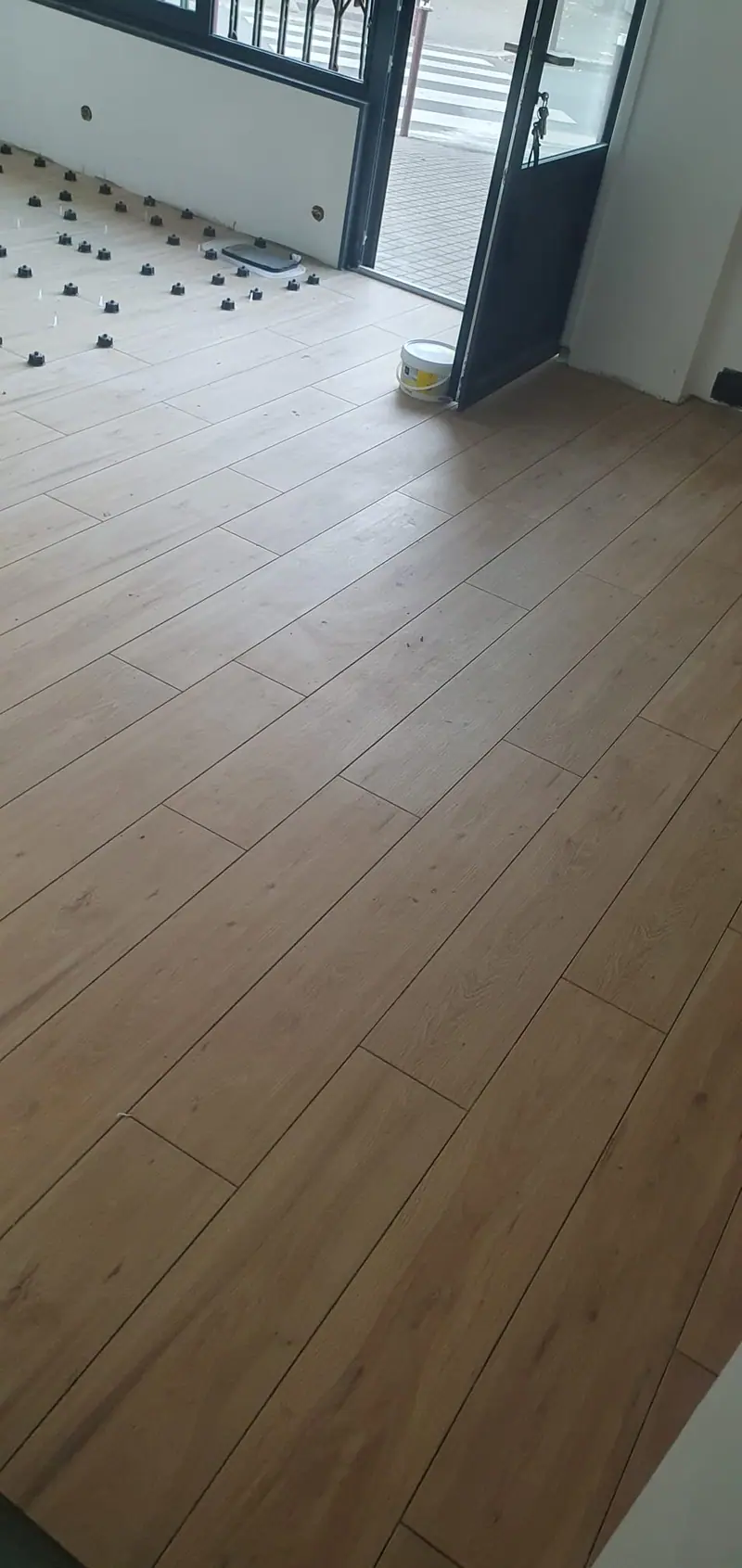 Carrelage effet bois posé jusqu’à une entrée vitrée
